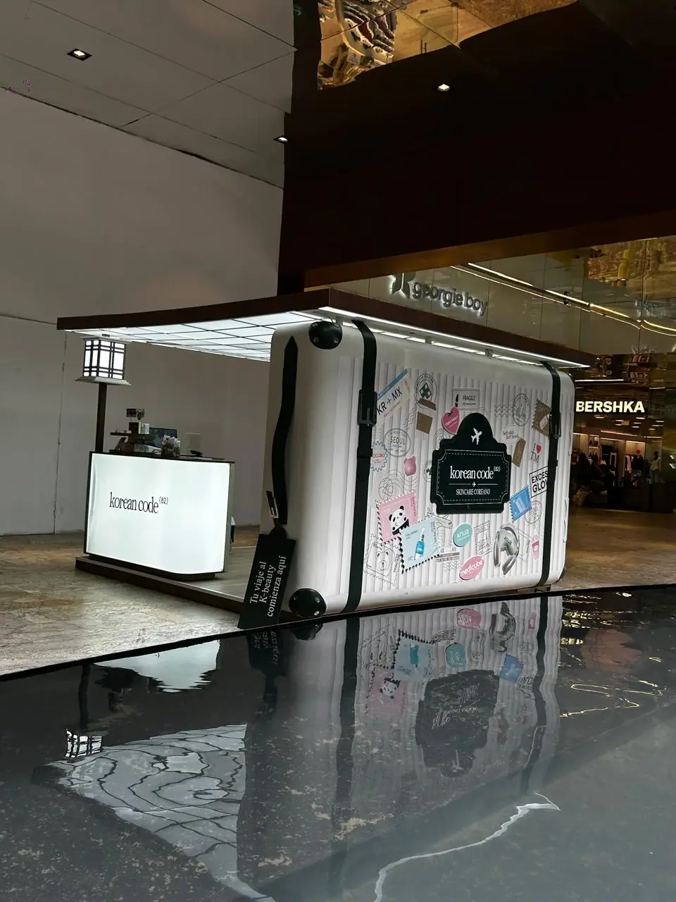 Kiosco de Korean Code con forma de maleta de viaje gigante en centro comercial